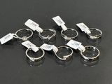 six silver rings with tags on them sitting on a black surface
