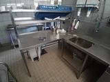 a large stainless steel kitchen with a sink and dishwasher