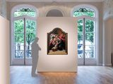 a man standing in front of a painting in a large room