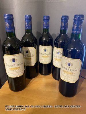 six bottles of red wine are lined up on a table