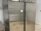 two stainless steel refrigerators in a kitchen with tile flooring