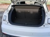 the back of a white car with its trunk open in a parking lot