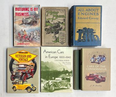 Plusieurs livres sont alignés sur une surface blanche, avec une voiture jaune devant eux.