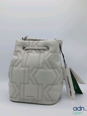 Le sac est blanc et présente un motif noir et blanc.