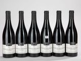 six bottles of wine are lined up in a row on a table
