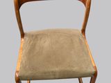 La chaise est en bois et son assise est verte.