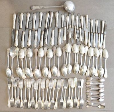 many spoons and forks laid out on a table
