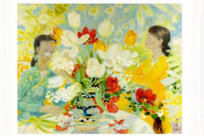 two women sitting at a table with flowers in a vase