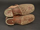 two pairs of shoes with rivets on them on a black surface