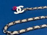 a close up of a chain with a pink bead on it