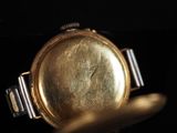 a close up of a gold watch with a black background