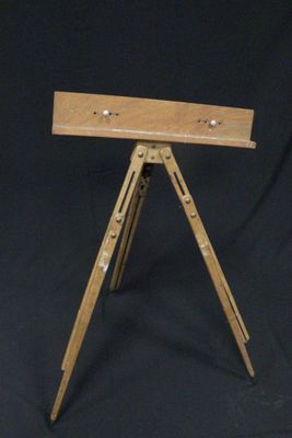 a small wooden tripod with a metal plate on top of it