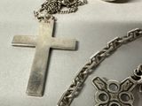 a cross on a chain next to a cup of coffee