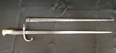 une vieille épée avec une poignée en bois posée sur un tissu noir
