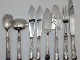 five forks and five spoons on a white table