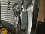 three beer taps on top of a dishwasher in a kitchen