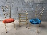 trois chaises métalliques recouvertes de fourrure bleue et orange devant un mur de briques
