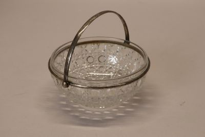 a small glass bowl with a handle on a table