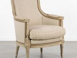 une chaise rayée de beige et de blanc posée sur un parquet en bois massif