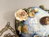 a blue and white vase with a flower on it