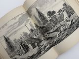 an open book with a drawing of a farm and a house
