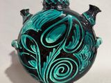 a blue vase with a black and green design on it