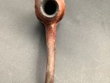 an old pipe sitting on top of a table next to a metal object