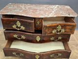 a marble top chest of drawers on a wooden floor
