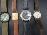 cinq modèles de montres différents sur un fond noir