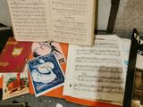 a lot of music books on a table next to a guitar
