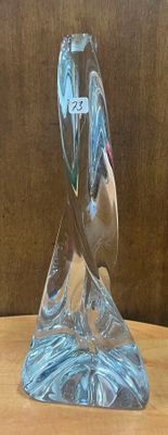 une sculpture en verre représentant un oiseau, posée sur une table en bois