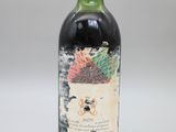 une vieille bouteille de vin posée sur une table blanche
