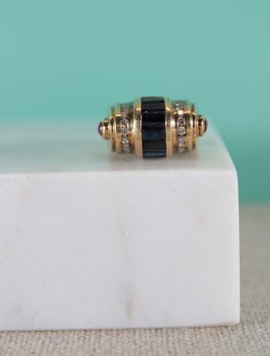 une image représentant une bague dorée et noire posée sur un bloc de marbre