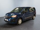 La camionnette bleue est garée dans une grande pièce au sol noir.