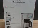 packaging of a coffee maker on a wooden table with a black background