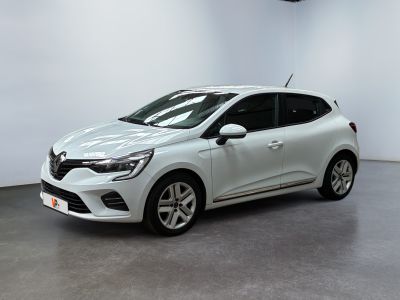 Une voiture blanche est garée dans une pièce aux murs blancs