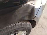 a close up of a car ' s front bumper with a denting on it