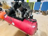a red air compressor sitting on top of a red tank