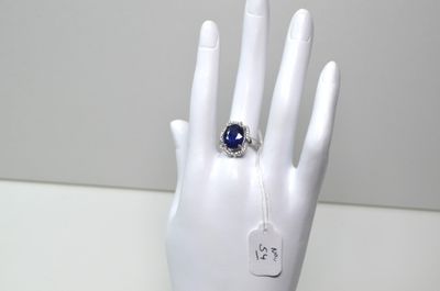 une main de mannequin blanche ornée d'une bague bleue