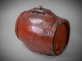 an old red vase sitting on top of a white surface