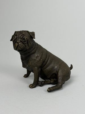 statue représentant un chien noir assis sur une surface blanche
