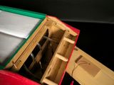 a red box with a green lid and a white container inside of it