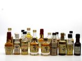 many bottles of alcohol lined up on a white surface