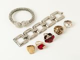 three pairs of rings and bracelets on a white surface