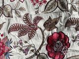 a close up of a quilt with flowers and leaves on it