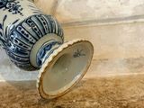 a blue and white vase sitting on a ledge