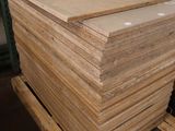a stack of plywood boards on a pallet in a warehouse