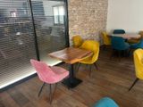 brightly colored chairs and tables in a restaurant with a brick wall