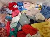 a bag full of clothes that is sitting on a bed