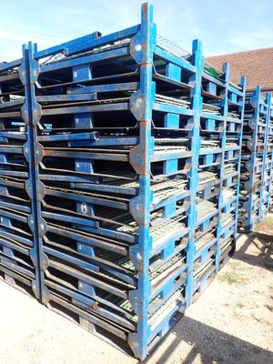 a pile of pallets sitting on top of a dirt field